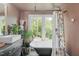 Unique bathroom with a vintage tub, elegant fixtures, and lots of natural light at 615 Beaver Creek Rd, Apex, NC 27502