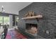 Living room fireplace featuring a dark painted brick wall and a wood mantel at 615 Beaver Creek Rd, Apex, NC 27502