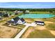 Gorgeous aerial view of the white farmhouse featuring a black roof, long driveway, garage, and a scenic pond at 6185 Nc-50, Benson, NC 27504