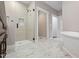 Spacious bathroom featuring glass shower with tiled niche, vanity with dark wood cabinets, and marble floors at 6185 Nc-50, Benson, NC 27504