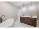 Bright bathroom featuring a soaking tub, dark wood vanity with double sinks, and pendant lights at 6185 Nc-50, Benson, NC 27504