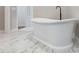 Elegant soaking tub with black faucet, complemented by hexagon marble-patterned floors at 6185 Nc-50, Benson, NC 27504