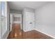 Bedroom with hardwood floors, double door closet, and open view to an adjacent living room at 6185 Nc-50, Benson, NC 27504