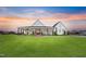 Stunning modern farmhouse exterior with a wide porch bathed in the warm glow of the sunset at 6185 Nc-50, Benson, NC 27504