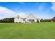 Exterior elevation of a modern farmhouse on a large lot with green grass at 6185 Nc-50, Benson, NC 27504