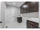 Laundry room features dark wood cabinets, marble-patterned floors, and a sink at 6185 Nc-50, Benson, NC 27504