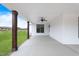 Side porch with dark-trimmed windows, wooden posts, ceiling fans and a scenic backyard view at 6185 Nc-50, Benson, NC 27504