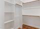 Bright walk-in closet with white shelves and wooden rods providing ample storage space at 6185 Nc-50, Benson, NC 27504