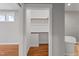 Walk-in closet boasts built-in shelves and wooden floors adjacent to a modern bathroom at 6185 Nc-50, Benson, NC 27504