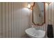Powder room featuring a stylish vanity, elegant mirror, and decorative wall covering at 6245 Hampton Ridge Rd, Raleigh, NC 27603