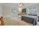 Spacious bedroom featuring a ceiling fan, two windows, and neutral carpeting at 6245 Hampton Ridge Rd, Raleigh, NC 27603