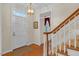 Elegant foyer featuring hardwood floors, a stylish light fixture, and staircase with wooden handrail at 6245 Hampton Ridge Rd, Raleigh, NC 27603