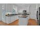 Modern kitchen featuring white cabinets, granite countertops, stainless steel appliances, and hardwood floors at 6245 Hampton Ridge Rd, Raleigh, NC 27603