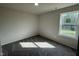 Well-lit carpeted bedroom with a large window showcasing outdoor scenery at 63 Coharie Dr, Lillington, NC 27546