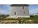 Side view of a two-story home with gray siding and a small back porch at 63 Coharie Dr, Lillington, NC 27546