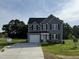 Charming two-story home with gray siding, black shutters, and a well-manicured front lawn at 63 Coharie Dr, Lillington, NC 27546