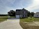 Beautiful two-story home with gray siding, a two-car garage, and a long concrete driveway at 63 Coharie Dr, Lillington, NC 27546