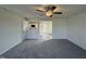 Bright and airy living room with neutral carpeting, a ceiling fan, and an open view to the kitchen area at 63 Coharie Dr, Lillington, NC 27546