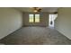 Spacious living room features neutral carpeting, a ceiling fan, and a view of the entryway and staircase at 63 Coharie Dr, Lillington, NC 27546