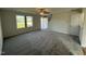 Bright living room with neutral carpet, ceiling fan, and a large window that floods the space with natural light at 63 Coharie Dr, Lillington, NC 27546