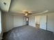 Spacious main bedroom with neutral carpet, tray ceiling, ceiling fan, and an en-suite bathroom at 63 Coharie Dr, Lillington, NC 27546