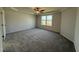 Large main bedroom featuring neutral carpeting, tray ceiling, ceiling fan, and a window for natural lighting at 63 Coharie Dr, Lillington, NC 27546