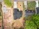 Aerial view of a new construction home with dark roof, driveway, and treed perimeter at 648 Shawnee Dr, Louisburg, NC 27549