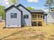 Backyard view of the home featuring a screened porch, well-maintained lawn and dark trim details at 648 Shawnee Dr, Louisburg, NC 27549