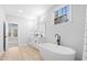 Primary bathroom with white vanities, soaking tub and natural light at 648 Shawnee Dr, Louisburg, NC 27549