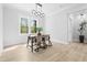 Bright dining room with modern chandelier, large window and a dark wood table set for four at 648 Shawnee Dr, Louisburg, NC 27549