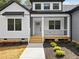 Charming home featuring a covered front porch with modern black trim and a well-manicured yard at 648 Shawnee Dr, Louisburg, NC 27549