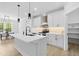 Modern kitchen with white cabinets, stainless steel appliances, a center island, and pendant lighting at 648 Shawnee Dr, Louisburg, NC 27549