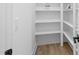 Bright pantry with white walls, light wood floors and open shelving at 648 Shawnee Dr, Louisburg, NC 27549