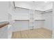 Walk-in closet with built-in shelving and racks; hardwood floors at 648 Shawnee Dr, Louisburg, NC 27549