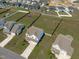 Aerial view showcases a white house, spacious yard, and neighborhood setting at 76 Arlie Ln, Lillington, NC 27546