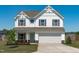 A charming two-story home with white siding, a covered entry, and a two-car garage at 76 Arlie Ln, Lillington, NC 27546