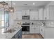 Well-equipped kitchen featuring stainless steel appliances, white cabinets, and tile backsplash at 76 Arlie Ln, Lillington, NC 27546