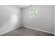Neutral bedroom featuring plush carpet, neutral paint, and a bright window at 804 Harper Rd, Hillsborough, NC 27278