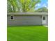 Rear view of home featuring a simple grey exterior with a door and a window at 804 Harper Rd, Hillsborough, NC 27278