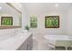Bright bathroom featuring mosaic tiled floors, large mirror, an elegant vanity and a soaking tub at 804 Old Mill Rd, Chapel Hill, NC 27514