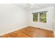 Bright bedroom features hardwood floors, ceiling fan, large window, and closet at 804 Old Mill Rd, Chapel Hill, NC 27514