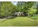 Expansive green lawn and mature trees surround this charming one-story home creating a serene setting at 804 Old Mill Rd, Chapel Hill, NC 27514