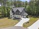 Aerial view of a two-story home with a long driveway, attached garage, manicured lawn, and wooded surroundings at 8237 Baronleigh Ln, Wake Forest, NC 27587