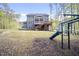Expansive backyard featuring a large deck, screened porch, playground, and lush lawn at 8237 Baronleigh Ln, Wake Forest, NC 27587