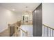 Upper hallway featuring hardwood floors, iron railing, decorative molding and a modern light fixture at 8237 Baronleigh Ln, Wake Forest, NC 27587