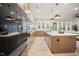 Modern kitchen featuring a large island with stone countertops, pendant lights and stainless steel appliances at 8237 Baronleigh Ln, Wake Forest, NC 27587