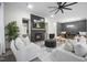 Open-concept living room featuring a sleek fireplace, stylish furniture, and a large ceiling fan at 8237 Baronleigh Ln, Wake Forest, NC 27587