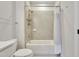 Bathroom featuring a shower over tub with tiled walls, toilet, and essential hardware at 8426 Garnet Rose Ln, Raleigh, NC 27615