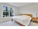 Bright bedroom with a light wood frame bed, and large window with lush tree views at 8426 Garnet Rose Ln, Raleigh, NC 27615