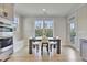 Sunlit dining area features a modern table, chairs, and scenic outdoor views at 8426 Garnet Rose Ln, Raleigh, NC 27615